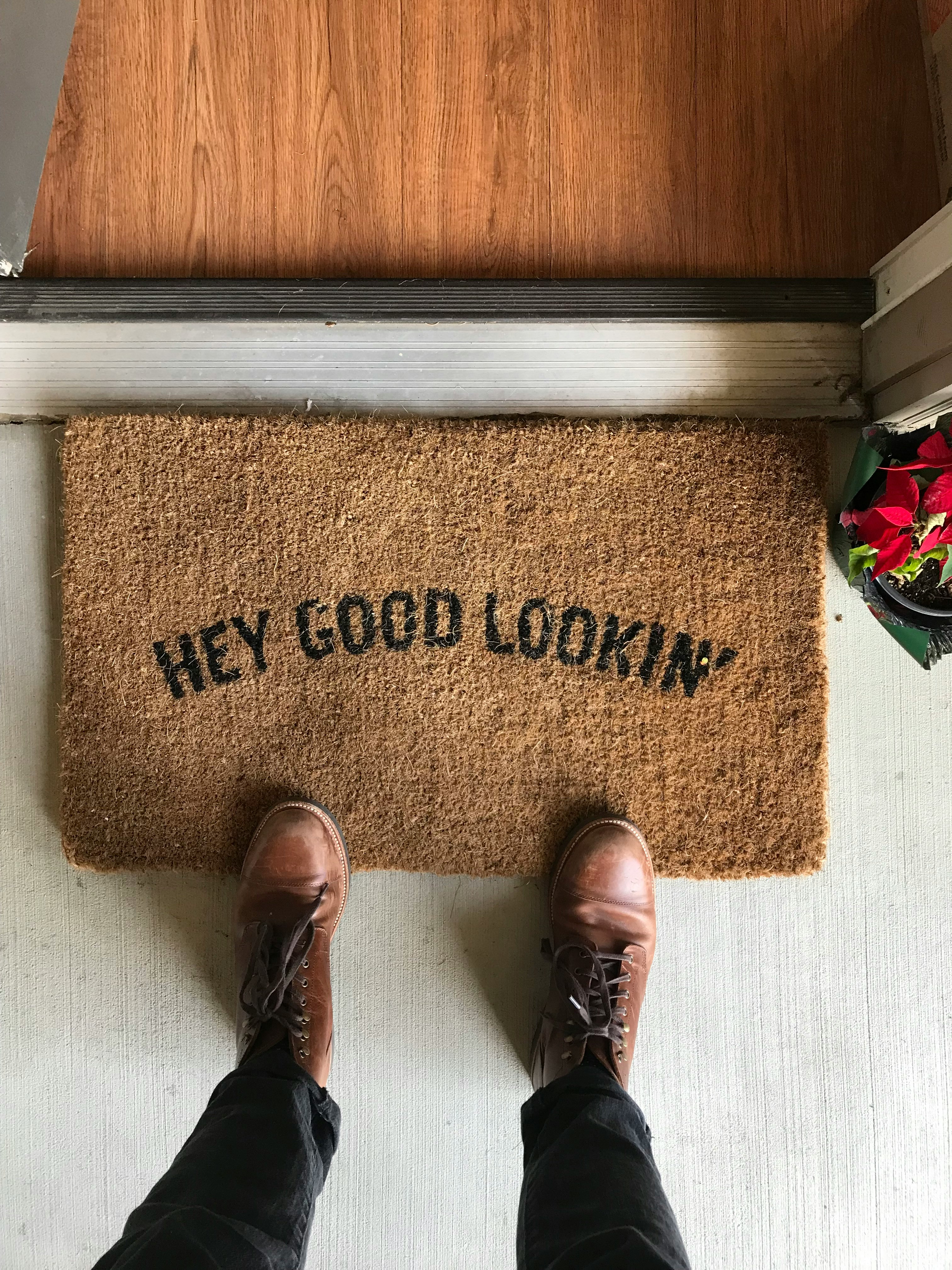 person in brown leather shoes standing on brown area rug